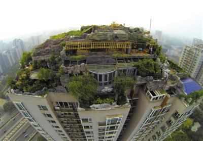 　　昨日，身穿橘黃色馬甲的工作人員在人濟(jì)山莊樓頂拆除違章建筑。新京報(bào)記者 吳江 攝