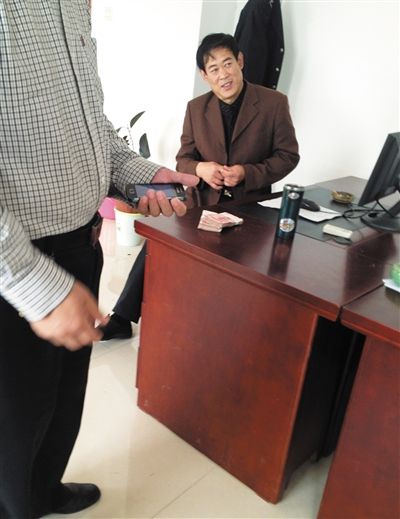 10月29日，獻(xiàn)縣國(guó)稅局稽查局辦公室內(nèi)，一名企業(yè)主交了兩萬(wàn)元現(xiàn)金在桌上。新京報(bào)記者 孟祥超 攝