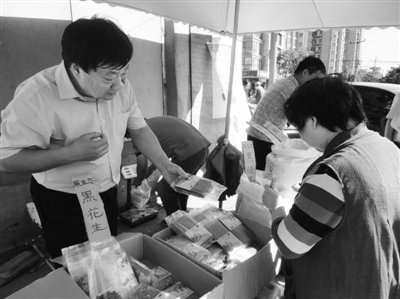 昨日，河南企業(yè)家劉春喜在京“練攤”，為顧客挑選綠豆。新京報(bào)記者 張玉學(xué) 攝
