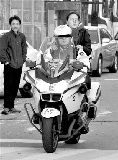 7日，首爾，警察將一名考生送抵考場。新華社發(fā)