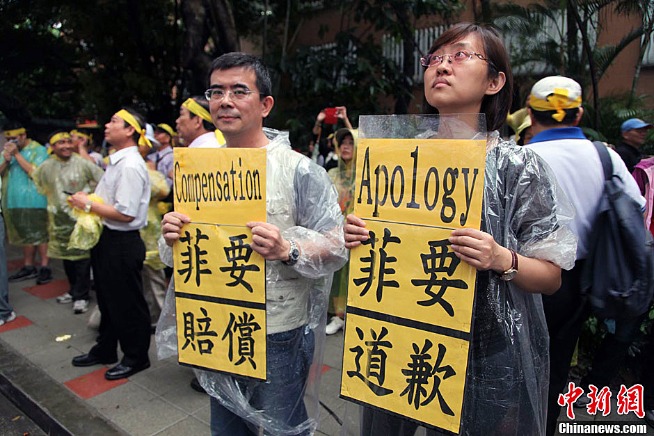 　圖為當天下午，當臺灣數(shù)百漁民在馬尼拉經濟文化辦事處前抗議時，有兩名年輕人手持標語，在路邊聲援。中新