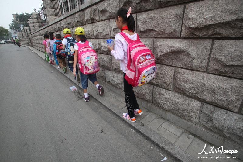 2013年09月11日，濟(jì)南運(yùn)署街上，小學(xué)生走史上“最窄人行道”上學(xué)。