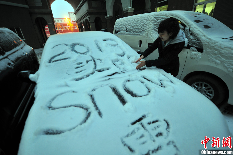 11月18日，行人在車輛的積雪上涂鴉。