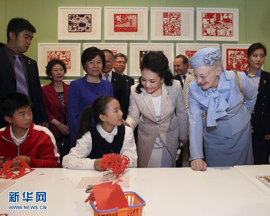 這是彭麗媛和瑪格麗特二世與根據(jù)安徒生童話(huà)中人物和情節(jié)制作剪紙的孩子交談。