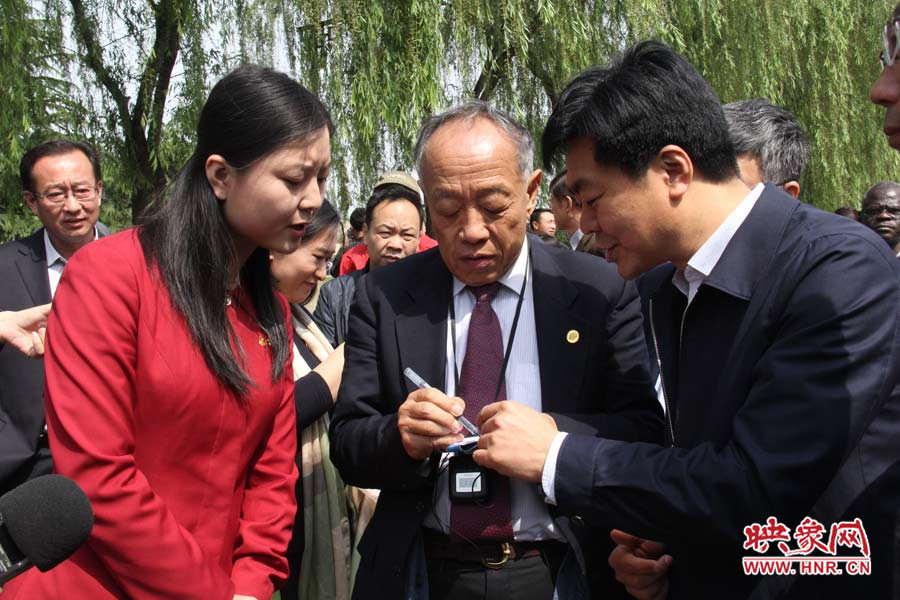 中國公共外交協(xié)會(huì)會(huì)長李肇星在龍門石窟記筆記