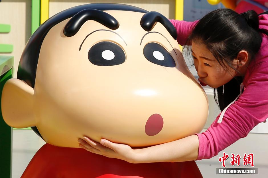 4月22日，游客與蠟筆小新合影?！跋灩P小新25周年紀(jì)念特展”日前在北京開展，吸引了不少市民游客。