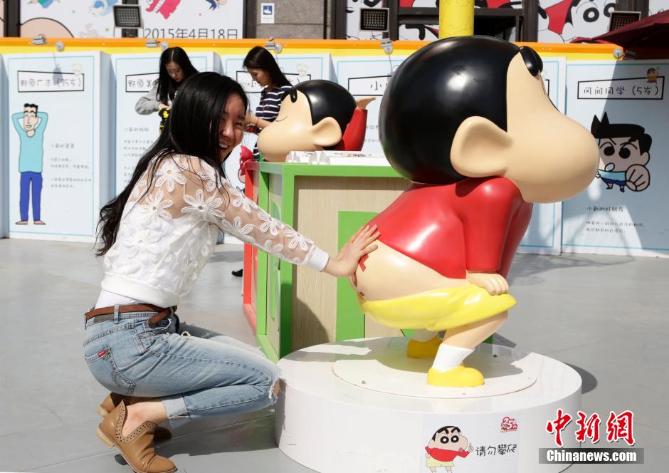 4月22日，游客與蠟筆小新合影?！跋灩P小新25周年紀(jì)念特展”日前在北京開展，吸引了不少市民游客。