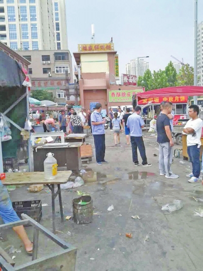 昨天，執(zhí)法人員在京廣路長江路口整治“僵尸圍擋”及圍擋內(nèi)的攤販。