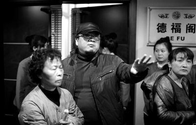 昨日，在河北香河天下第一城，相關(guān)負(fù)責(zé)人（左二）走出會議室與參加演出的老人們溝通。