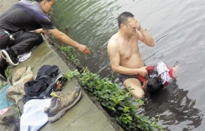 網(wǎng)友貼出民警張光聰一出河水就睜不開(kāi)眼，用手抹去臉上臟水的照片。