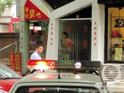 闖入面館的持刀男子與趕來的民警隔著玻璃門對峙，后店內(nèi)一名女童被其劫持。網(wǎng)友供圖