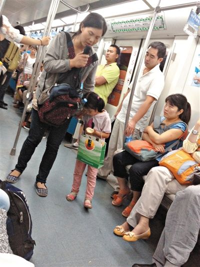 6月27日，舒馨帶一女孩在地鐵十號線行乞。她因被疑帶多個不同小孩乞討被警方搜尋。新京報(bào)記者 申志民 攝