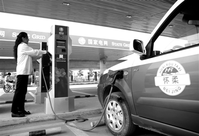 9月11日，懷柔區(qū)，電動(dòng)出租車司機(jī)正在為車輛充電。