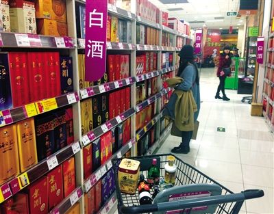 顧客在商場(chǎng)的高檔白酒貨架前駐足挑選。春節(jié)臨近，受“禁令”影響，以高檔白酒為代表的節(jié)日禮品市場(chǎng)面臨考驗(yàn)。記者 王遠(yuǎn)征 攝