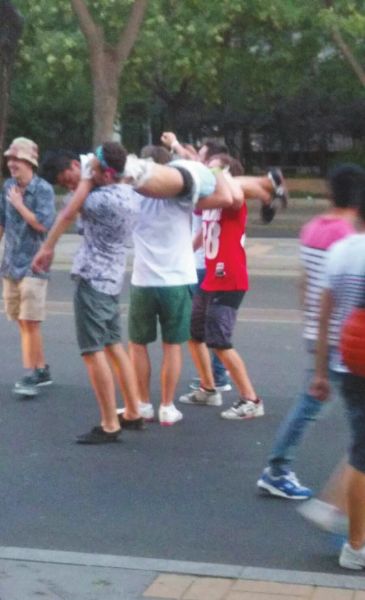 　四名外籍男子一同扛起醉漢拍照。