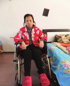 陳慶霞坐在輪椅上。她現(xiàn)在下身癱瘓，疾病纏身，生活不能自理。