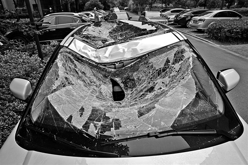 越野車車蓋以及前擋風(fēng)玻璃被砸得凹陷進(jìn)去。見(jiàn)習(xí)記者姚卡/攝
