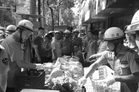7月11日，瀏陽市北正中路，執(zhí)法人員暫扣張海的水果。這是瀏陽市城管局拍攝的執(zhí)法現(xiàn)場圖。