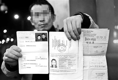 賀先生向記者出示他與越南妻子的結(jié)婚證、新娘護照和部分相關(guān)交費單據(jù) 攝影/本報記者　袁藝