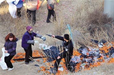 1月4日，連霍高速蘭州市榆中縣和平鎮(zhèn)段，一名警察舉著槍驅(qū)散哄搶橘子的村民。圖/CFP