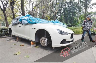 昨日，停放在重慶大學(xué)B區(qū)的一輛瑪莎拉蒂豪車被架在幾塊磚頭上，車輪不翼而飛。 重慶晨報(bào)記者 胡杰 攝