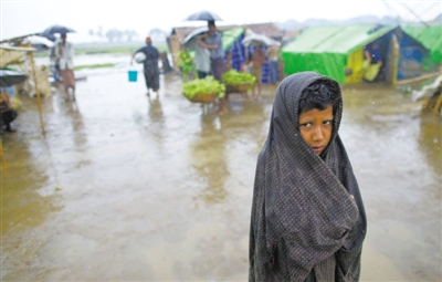 5月14日，緬甸若開邦實(shí)兌難民營，羅興亞族難民在雨中行走。熱帶風(fēng)暴“馬哈森”即將登陸緬甸，這里的難民開始乘船撤離。