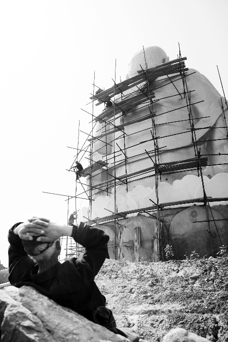 今年4月26日，工作人員將帆布蓋在“佛像”頭像上