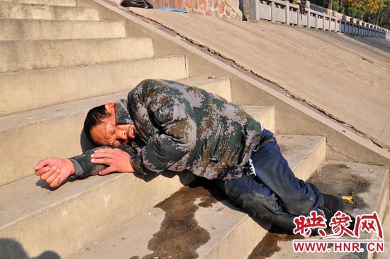 這名男子的衣服以及褲子全濕透了，水從衣褲里流出來，嘴里散發(fā)著濃烈的酒氣。