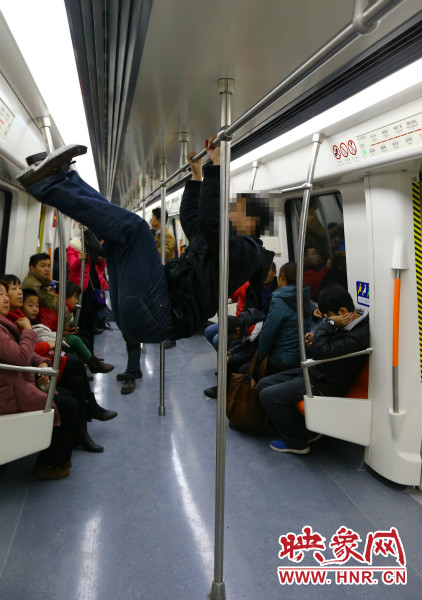 地鐵試乘日，一男子在車廂內(nèi)攀爬扶手自娛自樂