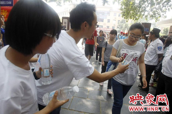 志愿者為剛剛考試完的考生送上1瓶冰凍的冰露·純悅，消暑解渴為考生加油