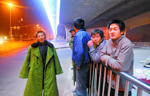 冬夜里，農(nóng)民工在橋下等著干活兒。