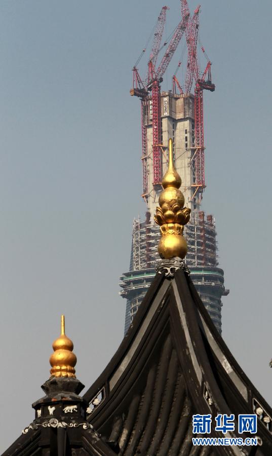 正在建設(shè)中的“上海中心”與豫園地區(qū)的傳統(tǒng)建筑（前）（4月11日攝）。