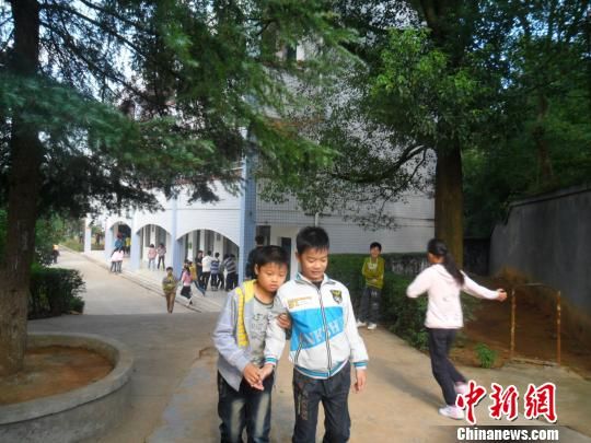 4年來(lái)，13歲的余興泉（左一）每天都攙扶著腿腳不便的同學(xué)左臣進(jìn)出教室、食堂和廁所。 李俊杰 攝