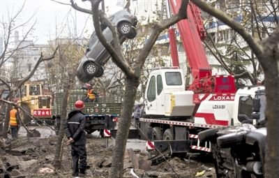 輸油管道爆炸后，搶修人員將被炸毀的車輛運(yùn)出現(xiàn)場。