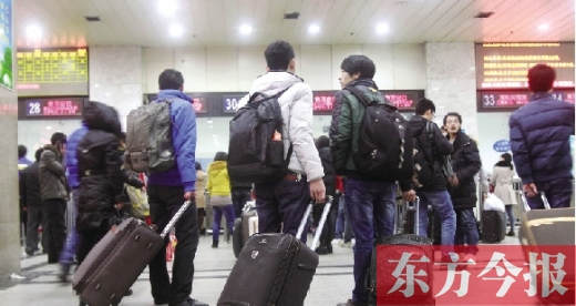 鄭州火車站東廣場(chǎng)售票大廳，幾名學(xué)生在售票窗口前躊躇