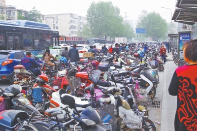 省人民醫(yī)院北門(mén)，路邊的公交站牌處停滿非機(jī)動(dòng)車(chē)，上、下客只能在快車(chē)道上。