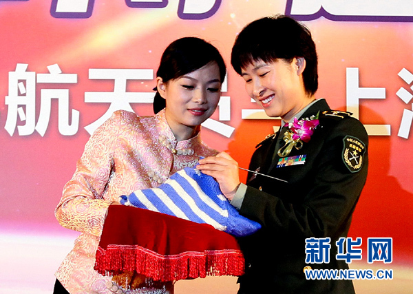 11月1日，航天員劉洋（右）在為“愛心”毛衣編織最后的收尾針。