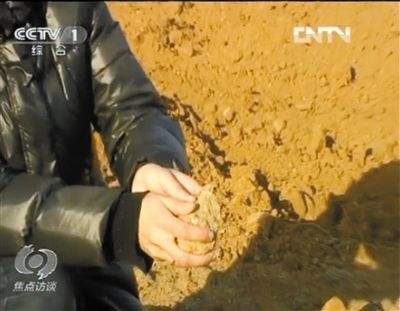 麻剛沙系麻剛石粉碎而成。記者找到一塊麻剛石，一捏就碎成粉末，硬度非常差。央視截圖