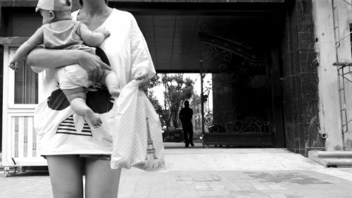 抱著孩子出售人奶的女子。