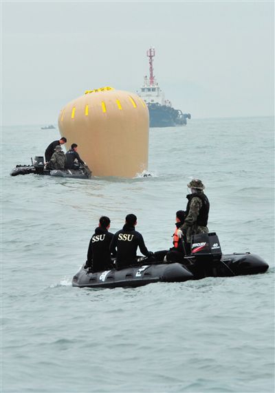 18日，搜救人員準備將氣囊捆綁到沉沒客輪上。