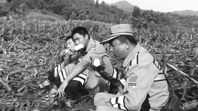 饑餓難忍，中國(guó)緊急救援河南基地的救援隊(duì)員在已毀的玉米地里撿拾生玉米吃。