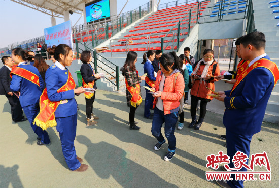 活動(dòng)現(xiàn)場工作人員給同學(xué)們發(fā)放宣傳冊(cè)、環(huán)保袋。