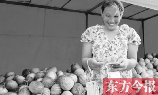 昨日，開封瓜農(nóng)史瑩瑩幸福地?cái)?shù)著賣瓜錢