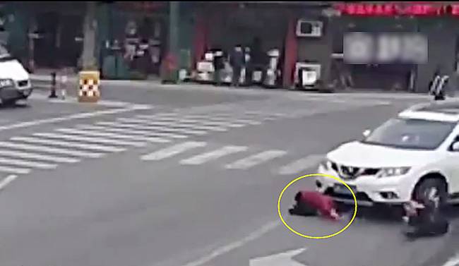 圖為小姑娘被卷進(jìn)車輪下瞬間。