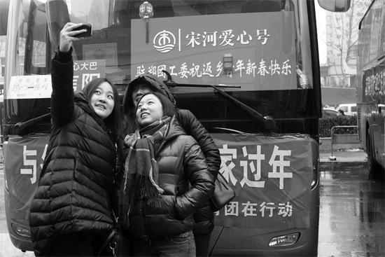 昨天上午8時(shí)，鄭州正道中環(huán)百貨廣場(chǎng)，準(zhǔn)備回家的老鄉(xiāng)在愛心大巴車前合影留念