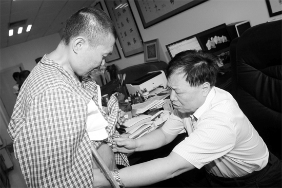 昨天，陜西西安第四軍醫(yī)大學(xué)唐都醫(yī)院骨腫瘤專家范清宇教授（右）在為李剛做檢查