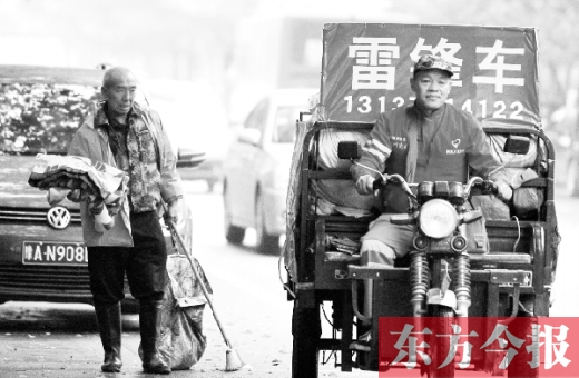 鄭州市商城路，一名環(huán)衛(wèi)工懷抱著剛剛收到的毯子，目送“雷鋒哥”孫德坤離開