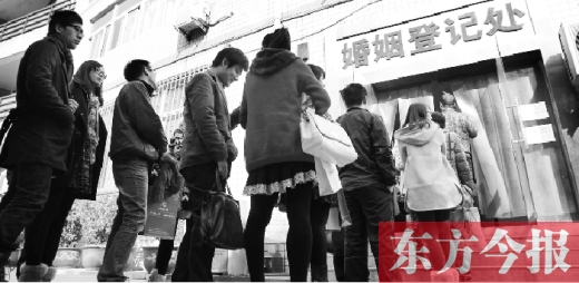 昨日，鄭州市中原區(qū)婚姻登記處等待“領證”的情侶們將隊伍延伸至辦事大廳大門外