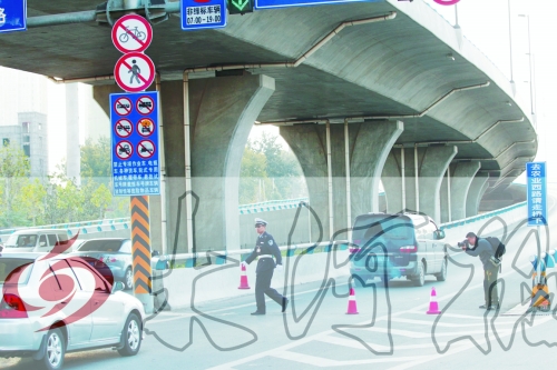 交警在東風(fēng)路從北向南上橋口處擺上反光錐，間歇放行