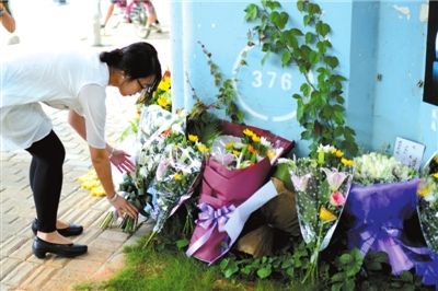 6月8日下午，記者來到廈門公交車爆炸事發(fā)現(xiàn)場橋下，附近已聚集了十幾個自發(fā)前來悼念的市民。橋墩下排放了一圈或黃或白的菊花，還有玖瑰、百合等。